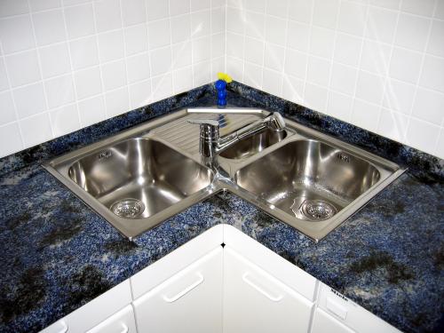 Großansicht einer leuchtend blauen 'Azul Bahia' Granit-Arbeitsplatte mit einem komplexen Muster aus großen weißen und grauen Kristalleinschlüssen, die eine dynamische und luxuriöse Textur erzeugen.